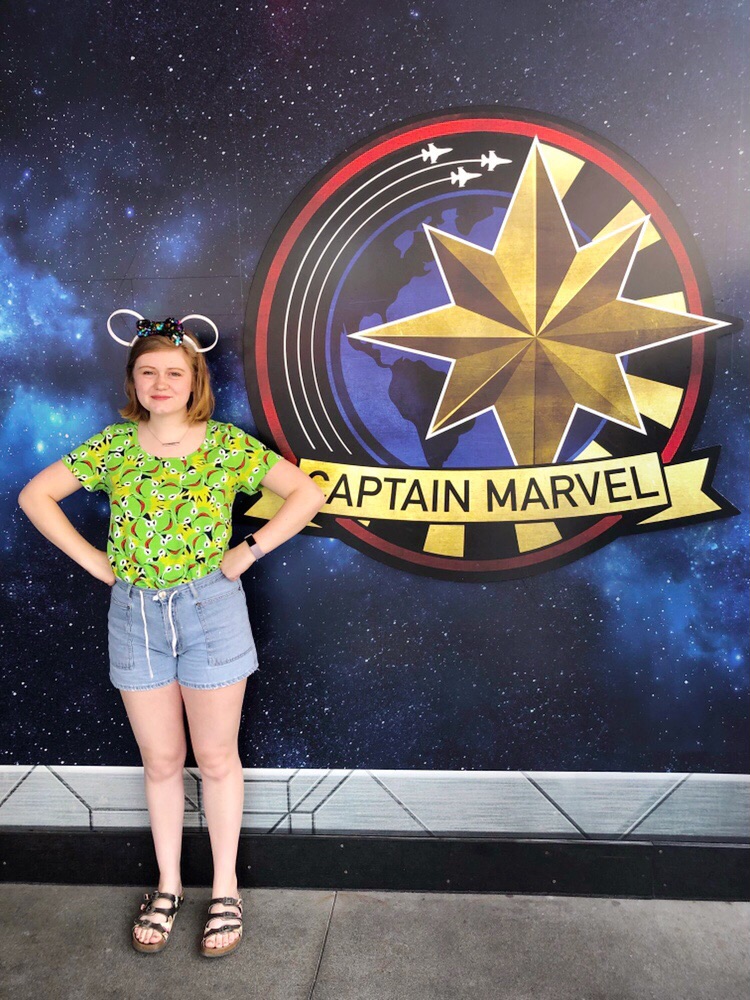 Hannah posing by Captain Marvel Emblem